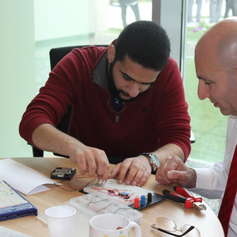An instructor demonstrating network wiring to students in a CCK lab, providing hands-on training in networking skills.
