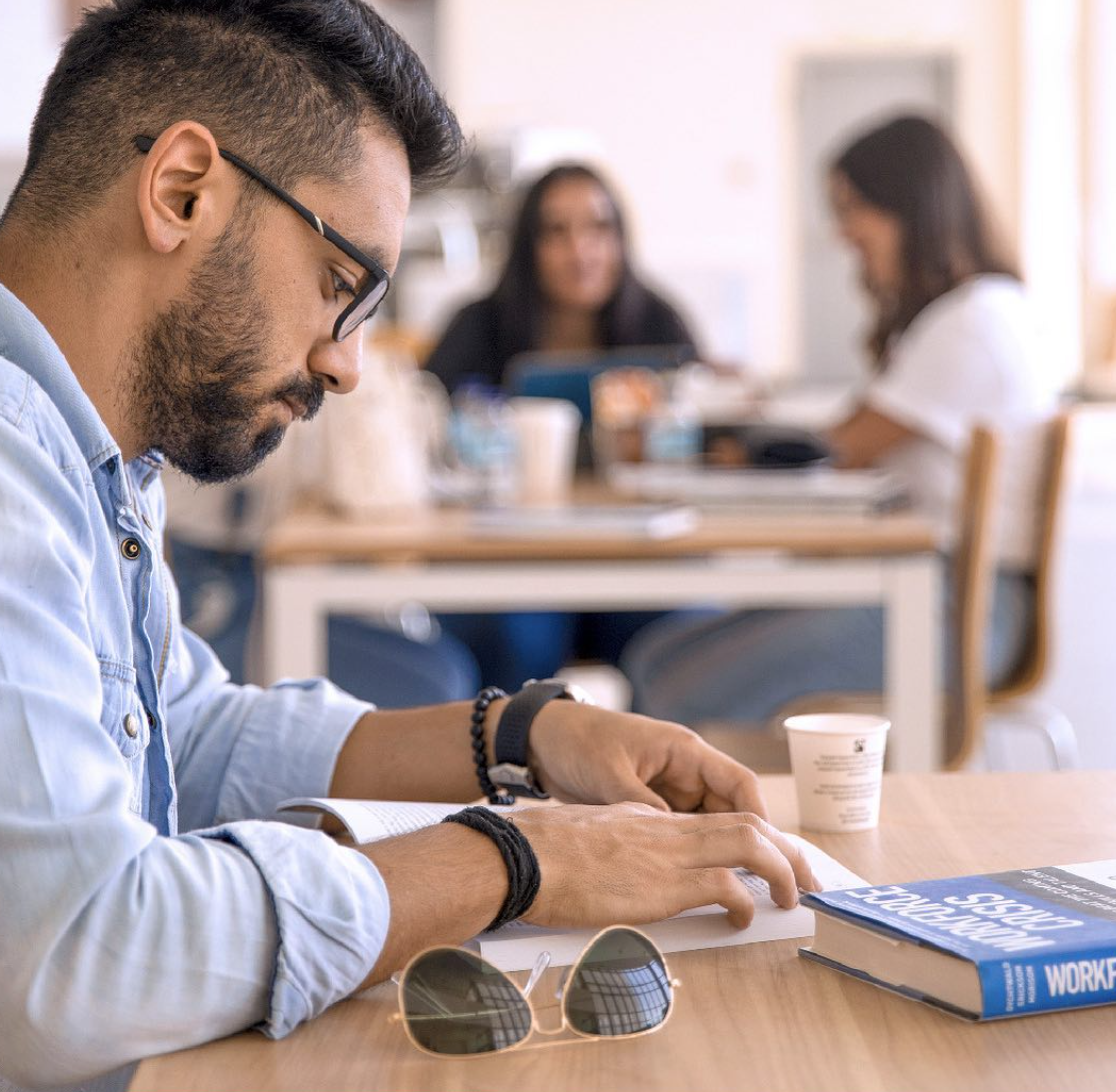A person reading a book, immersed in the content in a calm and focused setting.