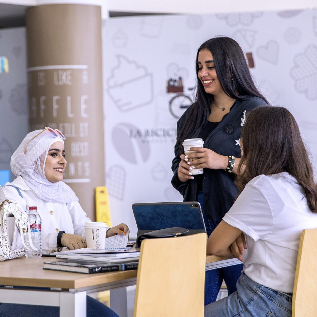 CCK female students enjoying a break together, engaging in lively conversation and building connections in a relaxed campus setting.