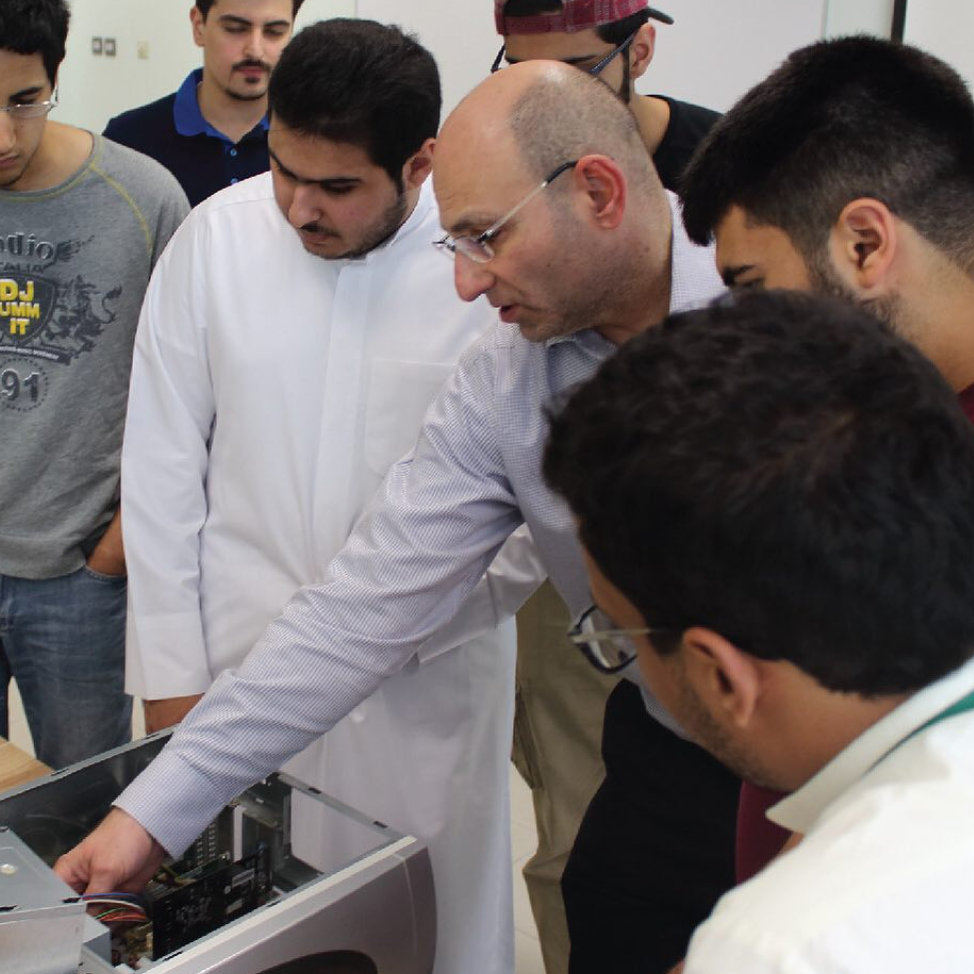 An instructor teaching students about computer components in a CCK lab, demonstrating hands-on learning in a technical environment.